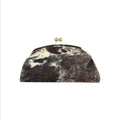 Jesalin Aluna rigid clutch bag in black and white cow print leather with a gold kiss lock frame