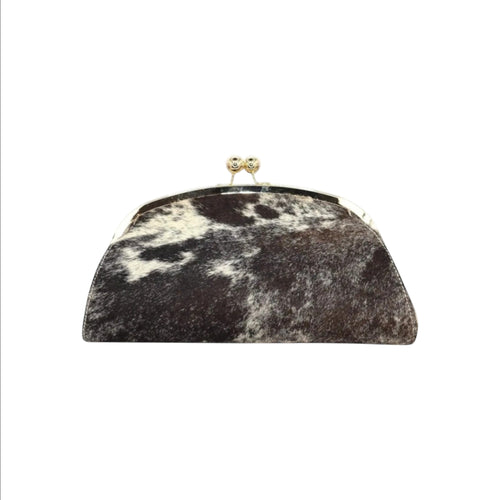 Jesalin Aluna rigid clutch bag in black and white cow print leather with a gold kiss lock frame