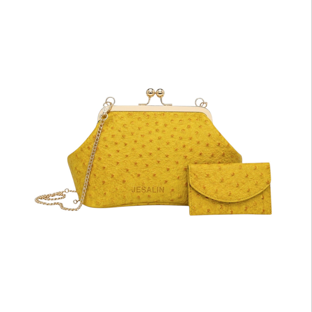 Bolso Jesalin Sette Petito amarillo en piel con grabado de avestruz, cierre kisslock dorado y cadena metálica.