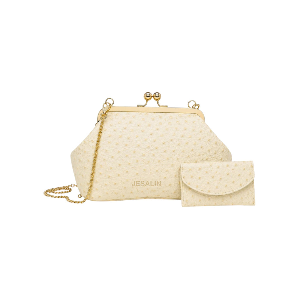 Bolso Jesalin Sette Petito en piel color hueso con grabado de avestruz, cierre kisslock dorado y cadena metálica.