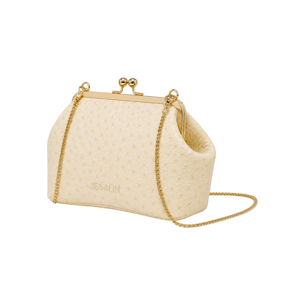 Bolso Jesalin Sette Petito en piel color hueso con grabado de avestruz, cierre kisslock dorado y cadena metálica.