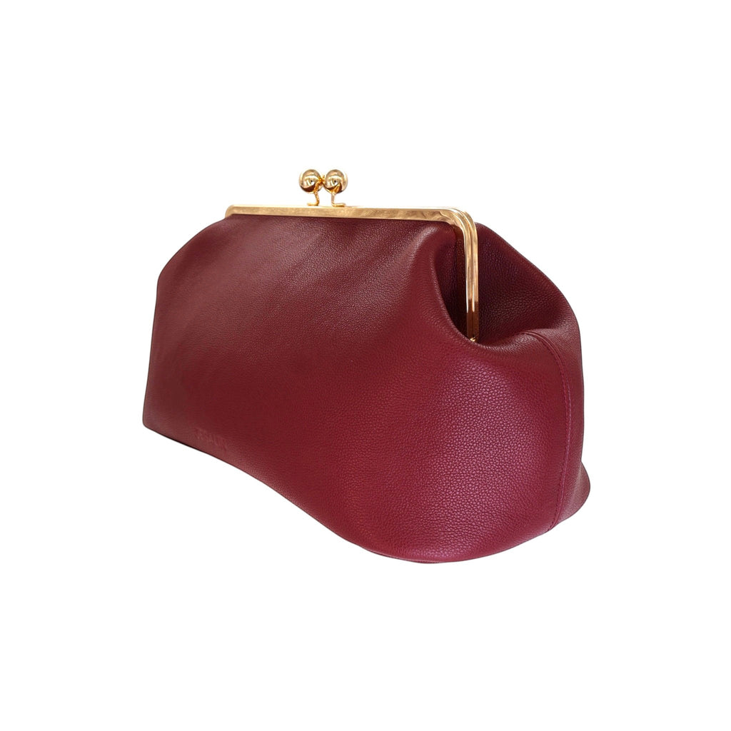 Bolso Jesalin Sette en piel bovina color vino, diseño estructurado con pliegues y cierre kisslock dorado.