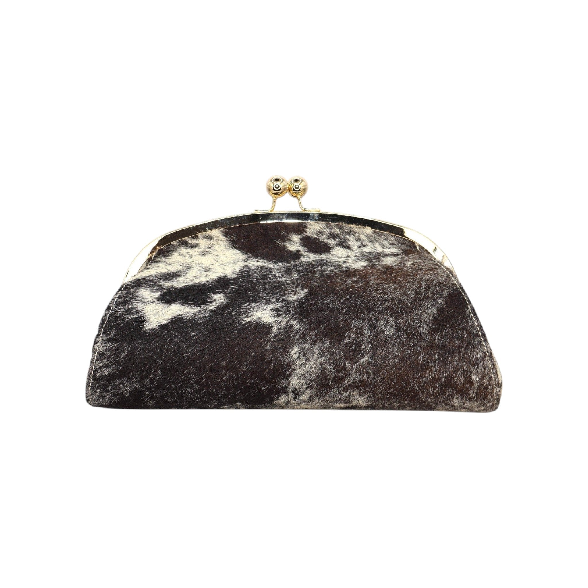 Clutch rígida Jesalin modelo Aluna en piel bovina con estampado de vaca, marco metálico dorado y cierre kiss lock.