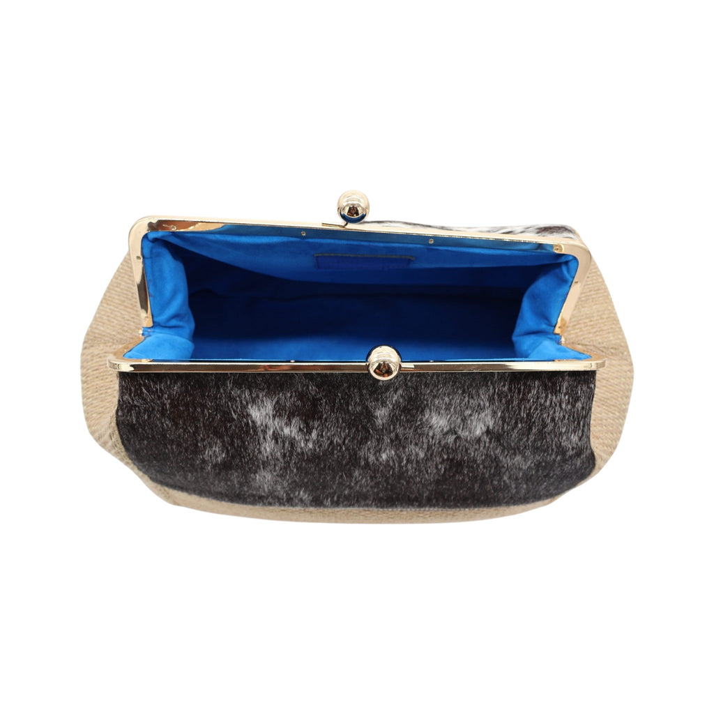 Jesalin Sette handbag in natural jute and cow print hair-on hide with a gold kiss lock frame and blue interior lining