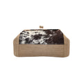 Jesalin Sette handbag featuring natural jute, cow print hair-on hide, and a gold kiss lock frame.